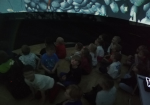 Dzieci oglądające film wewnątrz kopuły kina sferycznego